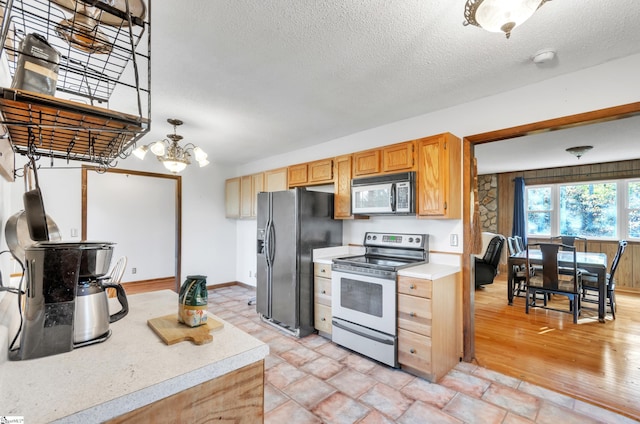 kitchen featuring electric range, hanging light fixtures, black refrigerator with ice dispenser, light hardwood / wood-style flooring, and a textured ceiling