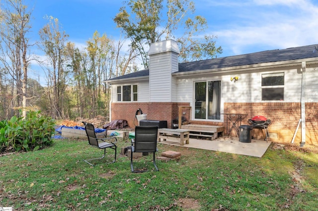 back of house with a lawn and a patio