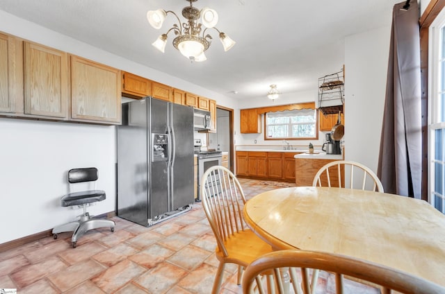 kitchen featuring electric stove, sink, black fridge with ice dispenser, and an inviting chandelier