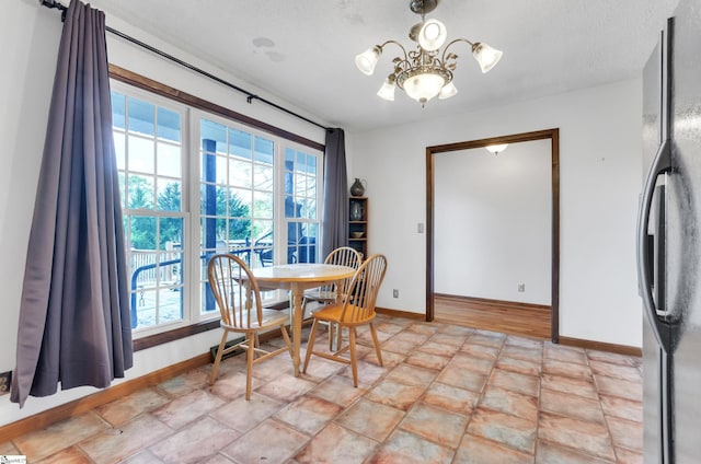 dining space with a notable chandelier, plenty of natural light, and a textured ceiling