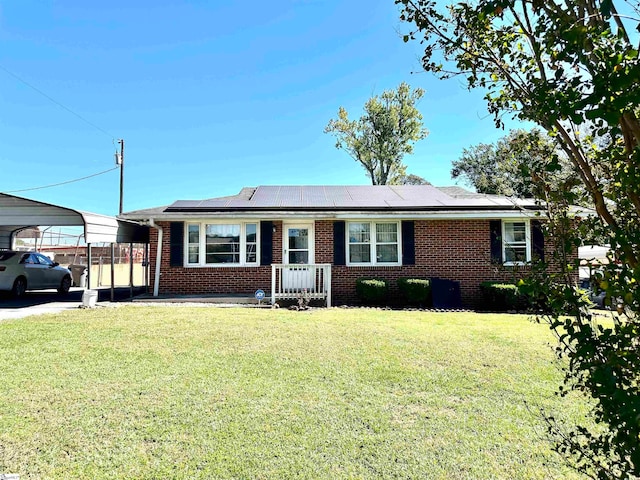 single story home with solar panels, a front lawn, and a carport