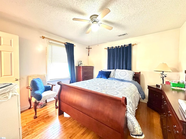 bedroom with wood-type flooring, a textured ceiling, and ceiling fan