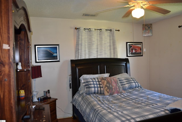 bedroom with ceiling fan and a textured ceiling