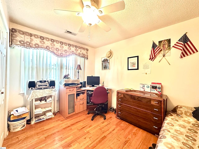 office area with light hardwood / wood-style floors, a textured ceiling, and ceiling fan