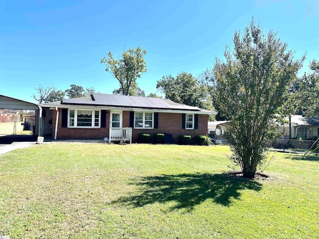 ranch-style home with solar panels and a front lawn