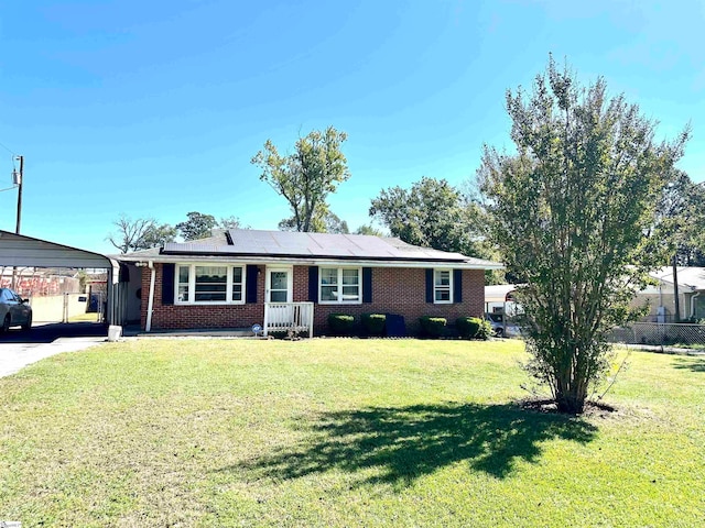 ranch-style house with solar panels, a front lawn, and a carport