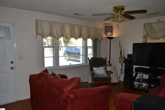 living room featuring ceiling fan, wood-type flooring, and a textured ceiling