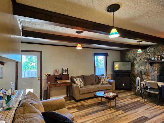 living room featuring beam ceiling, wood-type flooring, and a textured ceiling