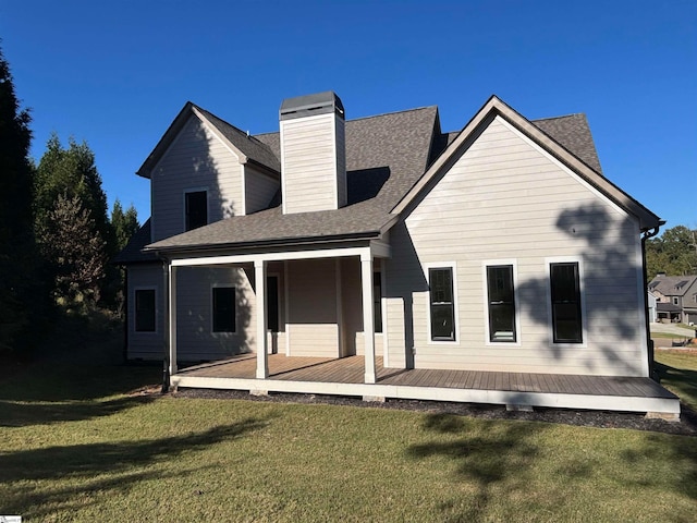 rear view of property featuring a lawn and a deck