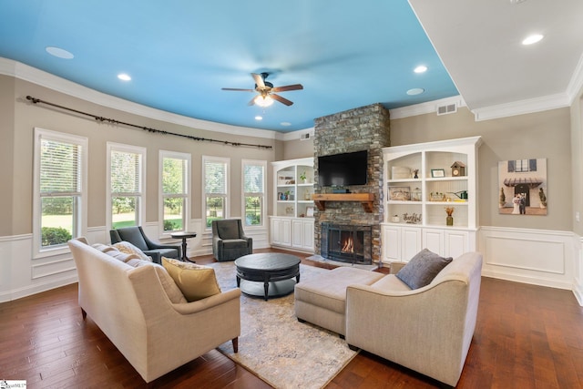 living room featuring ceiling fan, a fireplace, crown molding, and dark hardwood / wood-style floors