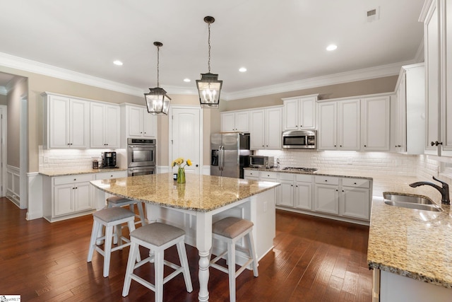 kitchen with dark wood-type flooring, white cabinets, appliances with stainless steel finishes, and sink