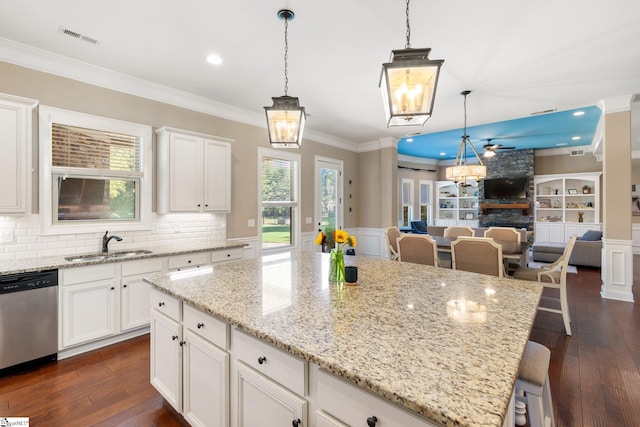 kitchen with white cabinets, sink, dark hardwood / wood-style flooring, hanging light fixtures, and dishwasher