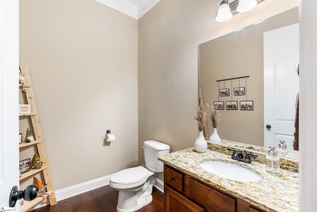 bathroom with wood-type flooring, ornamental molding, vanity, and toilet