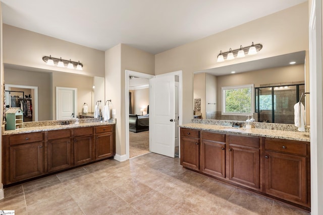 bathroom featuring tile patterned flooring, a shower with door, and vanity