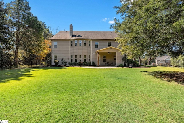 rear view of house with a lawn and a patio area