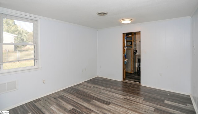 spare room featuring ornamental molding and dark hardwood / wood-style floors