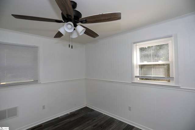 spare room featuring crown molding, dark wood-type flooring, and ceiling fan