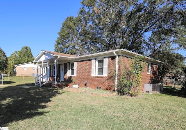 view of front of house featuring cooling unit and a front yard