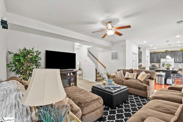 living room featuring ceiling fan and dark hardwood / wood-style floors