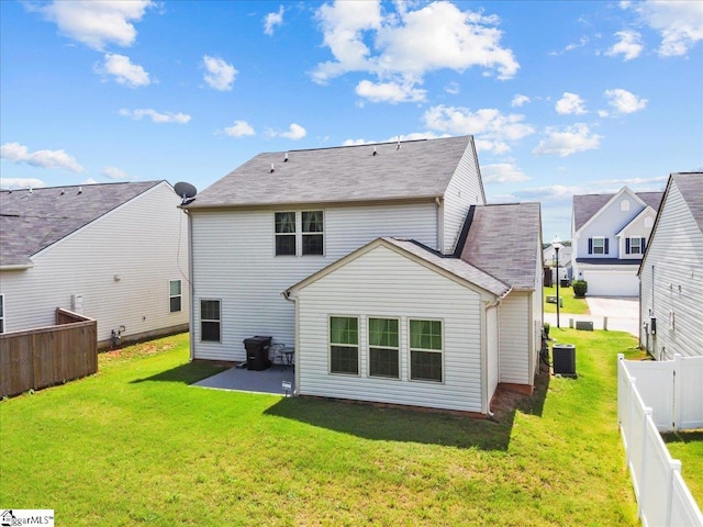 rear view of house featuring central AC unit, a yard, and a patio area