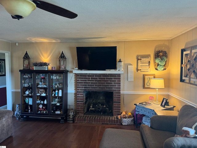 living room featuring ceiling fan, hardwood / wood-style floors, a fireplace, and a textured ceiling