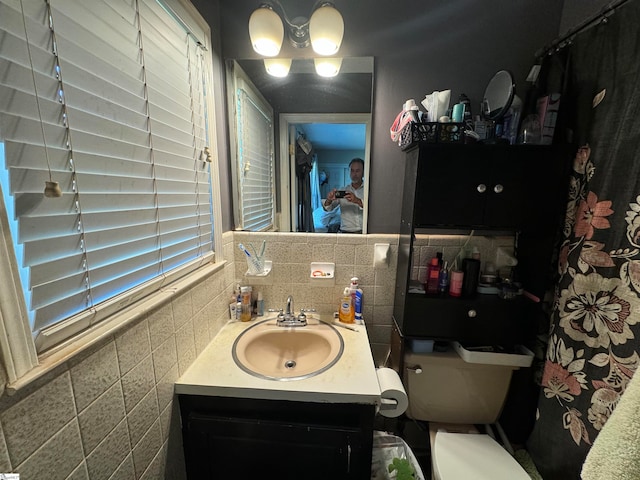 bathroom featuring toilet, vanity, and tasteful backsplash