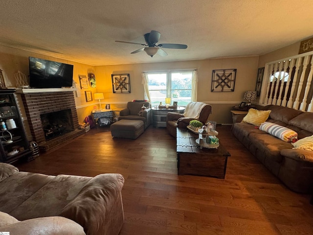 living room with a brick fireplace, a textured ceiling, dark hardwood / wood-style flooring, and ceiling fan