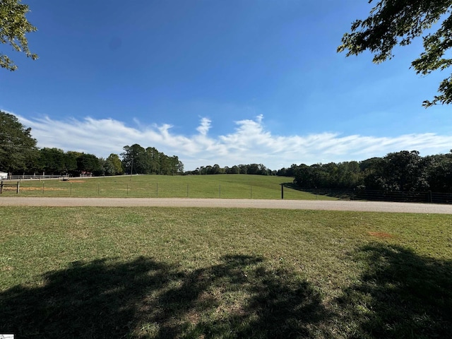 view of home's community with a rural view and a yard