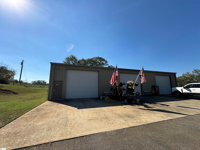 view of front facade featuring an outdoor structure, a garage, and a front lawn