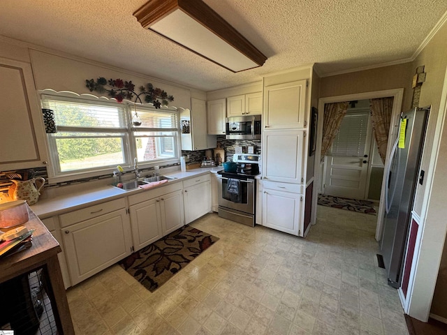 kitchen featuring sink, a textured ceiling, white cabinets, and stainless steel appliances