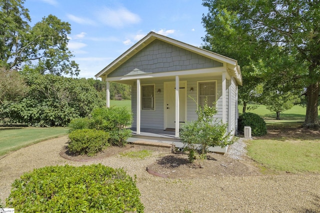 bungalow-style house featuring a porch, a front yard, and central AC unit