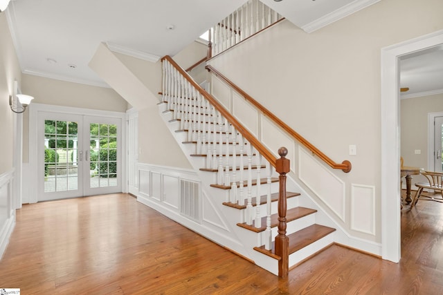 10490 New Cut Rd, Campobello, SC 29322 - stairs featuring crown molding, wood finished floors, a decorative wall, french doors, and wainscoting