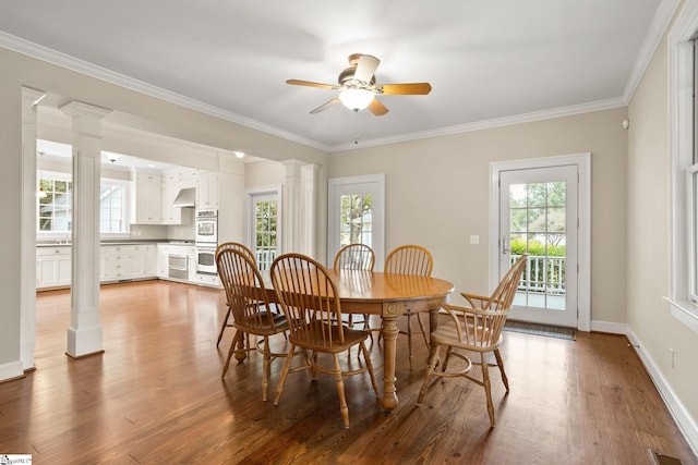 dining area with hardwood / wood-style flooring, ornate columns, and a wealth of natural light