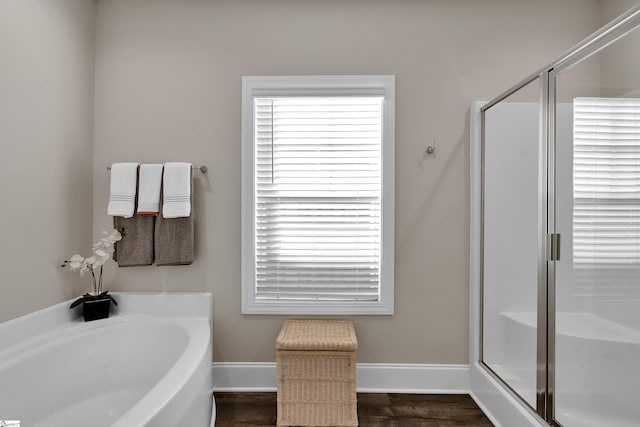 bathroom featuring hardwood / wood-style floors and plus walk in shower