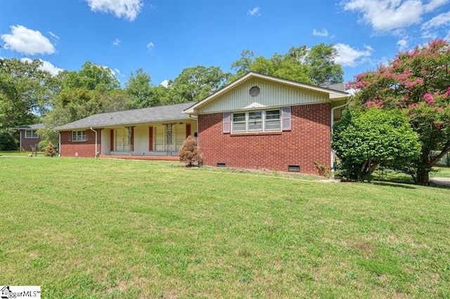 ranch-style home featuring a front lawn and covered porch