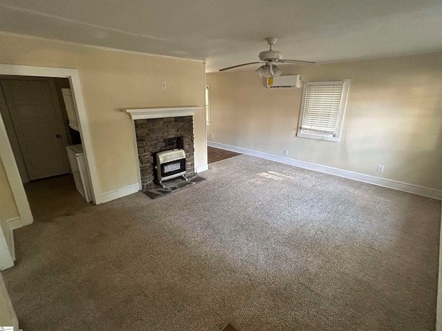 unfurnished living room with a wall unit AC, ceiling fan, a wood stove, heating unit, and carpet flooring