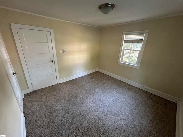 carpeted spare room featuring crown molding