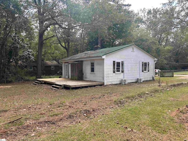 view of home's exterior featuring a deck and a lawn