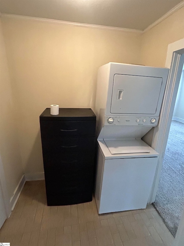 laundry room featuring ornamental molding, light wood-type flooring, and stacked washer / drying machine