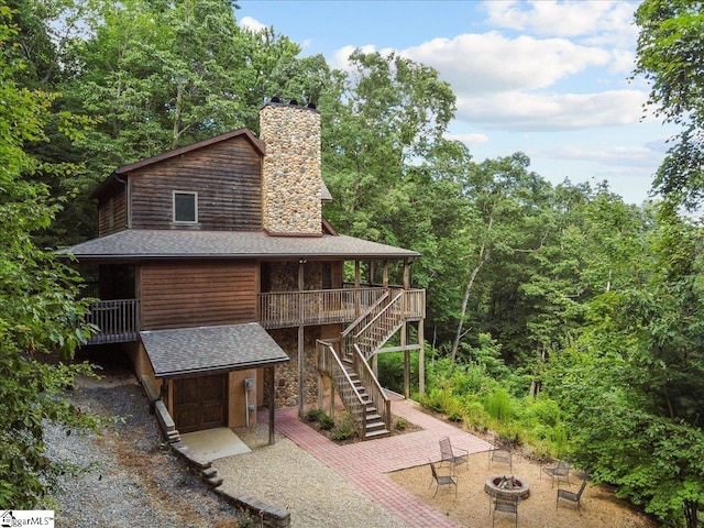 exterior space featuring an outdoor fire pit, a deck, and a patio area