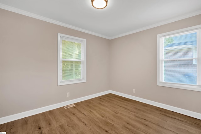 unfurnished room with hardwood / wood-style flooring and ornamental molding