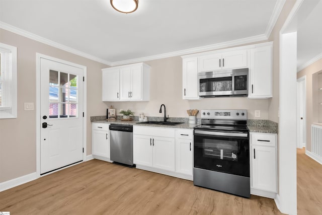 kitchen featuring stainless steel appliances, white cabinets, sink, and light wood-type flooring