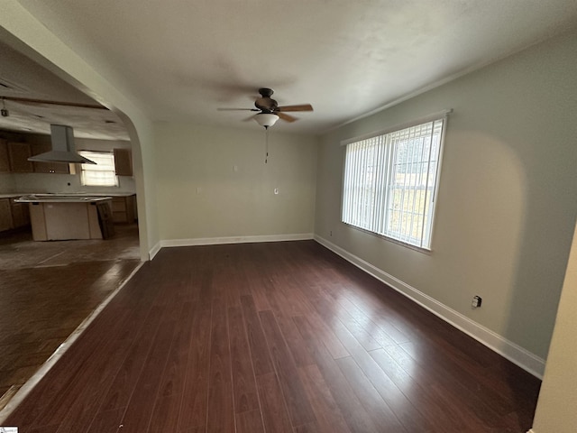 unfurnished living room with ceiling fan, plenty of natural light, and dark hardwood / wood-style floors