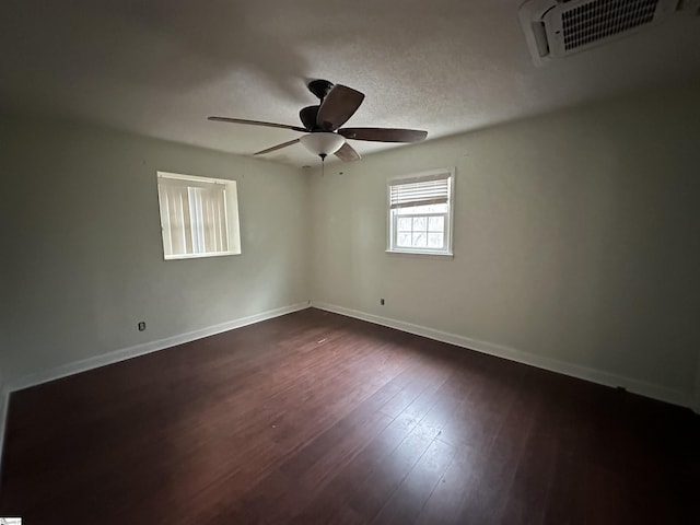 empty room with ceiling fan and dark hardwood / wood-style flooring