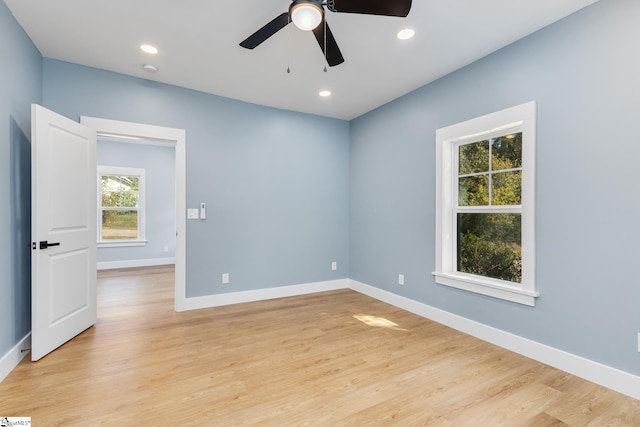 spare room featuring light hardwood / wood-style flooring, a healthy amount of sunlight, and ceiling fan