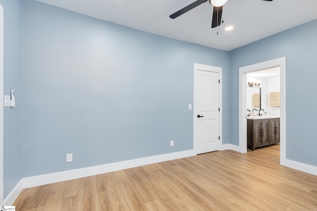 unfurnished bedroom with light hardwood / wood-style floors, ensuite bathroom, sink, and ceiling fan