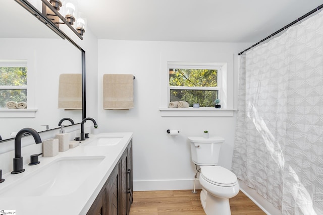 bathroom featuring vanity, hardwood / wood-style floors, a shower with curtain, and toilet