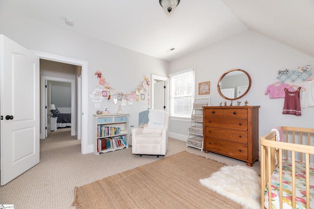 carpeted bedroom with vaulted ceiling and a crib