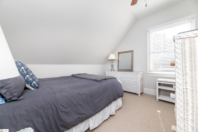 bedroom with ceiling fan, vaulted ceiling, and light colored carpet