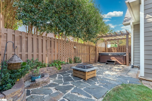 view of patio with a hot tub, a fire pit, and a pergola